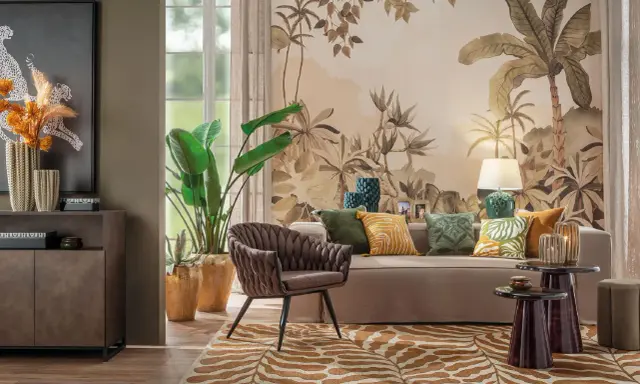 Un salotto con un murale botanico, mobili eleganti e raffinate decorazioni. Un divano beige, una poltrona marrone e un tappeto animalier creano un'atmosfera accogliente.