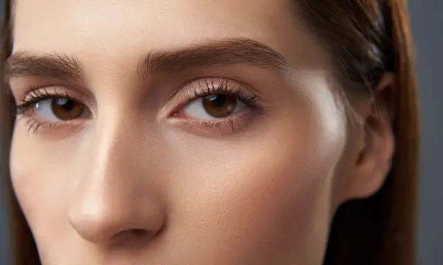 Maquillaje sutil realza unos preciosos ojos marrones, con pestañas definidas y un toque de brillo en los párpados.