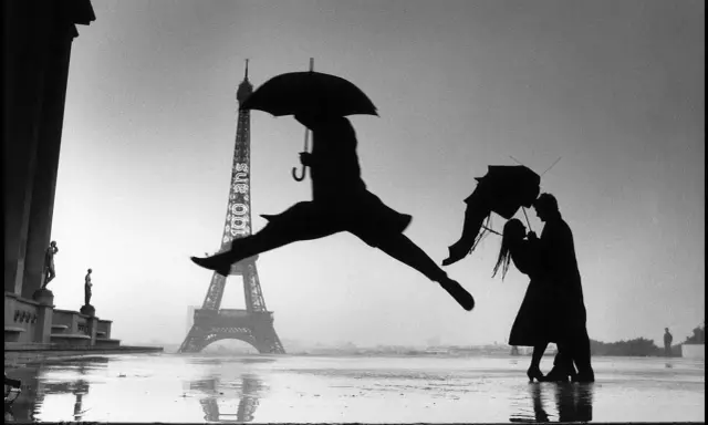 Parigi sotto la pioggia: una silhouette salta con un ombrello, mentre una coppia balla. Le foto più belle di sempre.