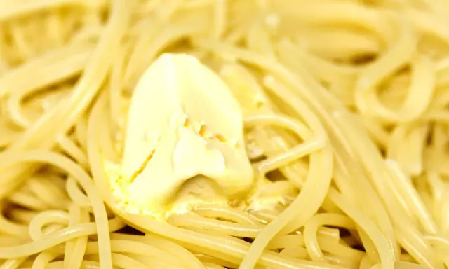 Un piatto di pasta in bianco fumante, con una generosa porzione di burro che si scioglie lentamente.