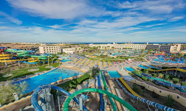 Wodne szaleństwo w Titanic Resort & Aquapark! Kolorowe zjeżdżalnie, baseny i palmy pod błękitnym niebem.