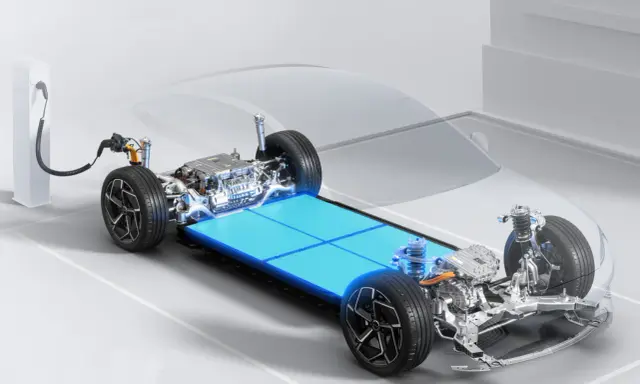 Telaio di un'auto elettrica con un pacco di **batterie al litio per auto elettriche** luminoso e un cavo di ricarica collegato.