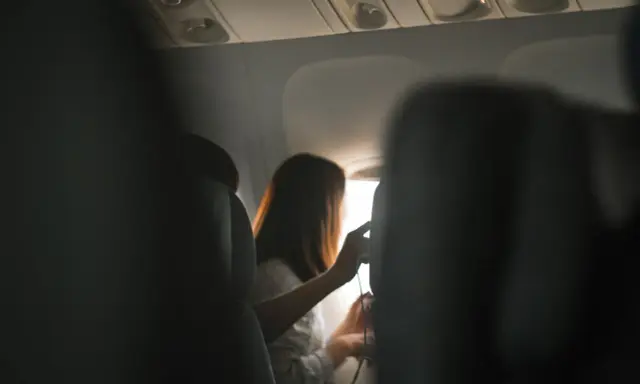 Wnętrze samolotu, pasażerka przy oknie. Zastanawiasz się, ile trwa lot z Gdańska do Antalyi?