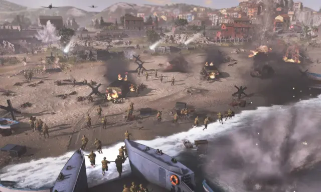 Desant na plażę w Company of Heroes. Żołnierze szturmują brzeg, płoną pojazdy, w tle miasto.
