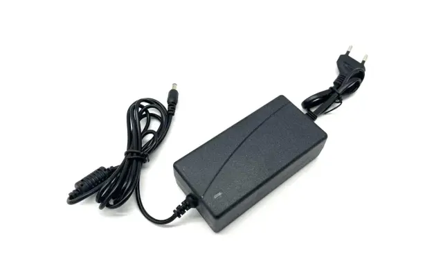 Schwarzes Netzteil mit Kabeln und Stecker, 12V 5A Leistung.