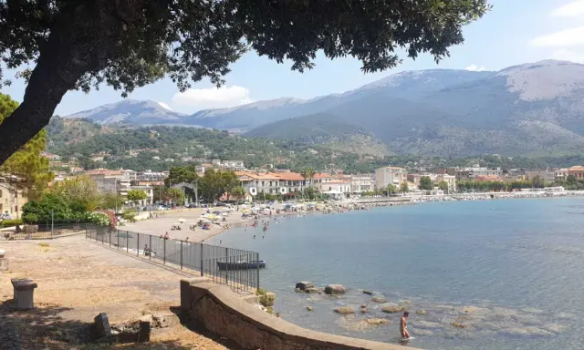 Vista panoramica di Sapri: una spiaggia affollata, il mare azzurro e le montagne sullo sfondo. Ecco cosa vedere a Sapri per una vacanza indimenticabile.