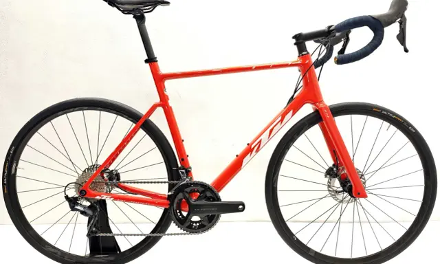 Czerwony rower szosowy KTM Revelator Alto z napędem Ultegra, gotowy na podbój szos.