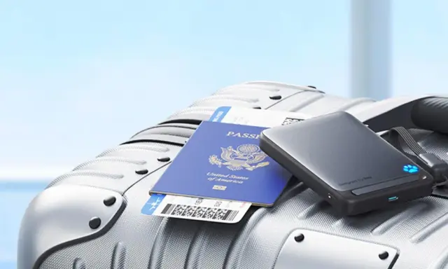 En powerbank, pass och flygbiljett ligger på en resväska, redo för resan med flygplan.