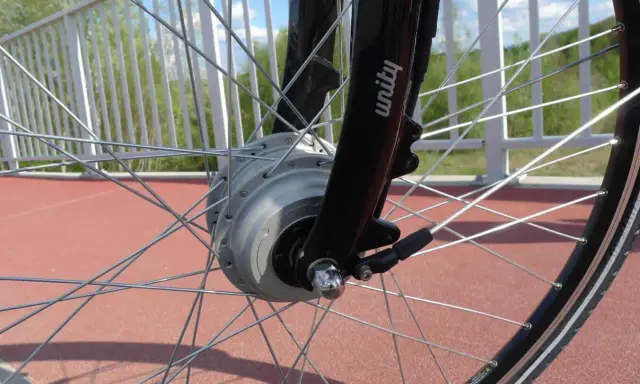 Szprychowe koło roweru elektrycznego z widocznym silnikiem w piaście. Czy na rower elektryczny trzeba mieć prawo jazdy? Sprawdź przepisy!
