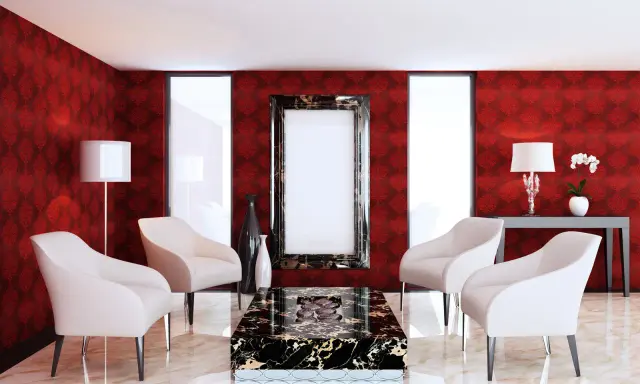 Elegancki salon z tapetą w różne rodzaje czerwieni, kremowymi fotelami i marmurowym stolikiem.