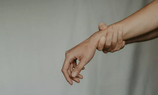 Dłoń trzymająca inną dłoń za nadgarstek. Zaborcza osoba nie chce puścić.