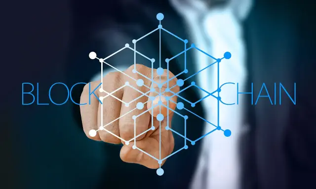 Dłoń wskazująca na sieć połączonych węzłów, symbolizującą blockchain w logistyce.