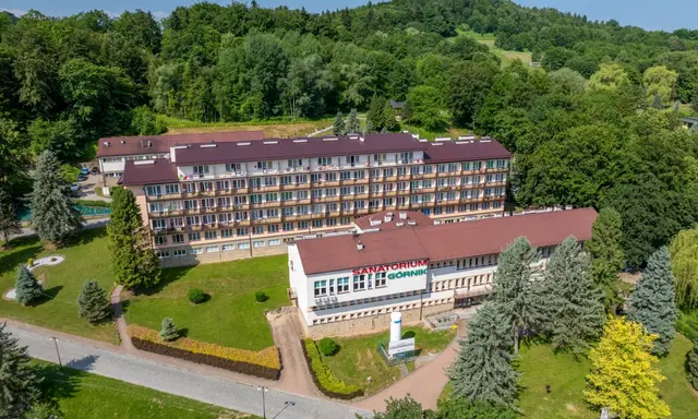 Sanatoria pełnopłatne w Iwoniczu-Zdroju: rozległy kompleks budynków otoczony zielenią, z widocznym napisem "Sanatorium Górnik".