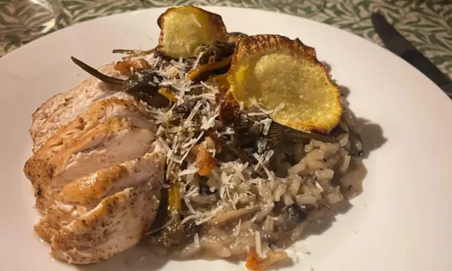 En krämig svamprisotto med skivad kycklingfilé och krispiga potatisskal. Ett perfekt risotto recept för en mysig middag.