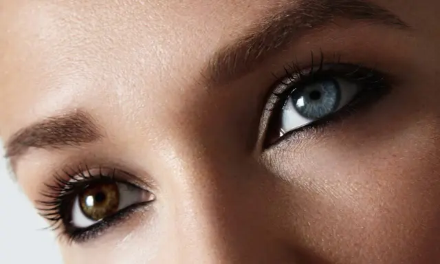 Oczy z heterochromią centralną: jedno niebieskie, drugie brązowe. Makijaż podkreśla ich niezwykły urok.