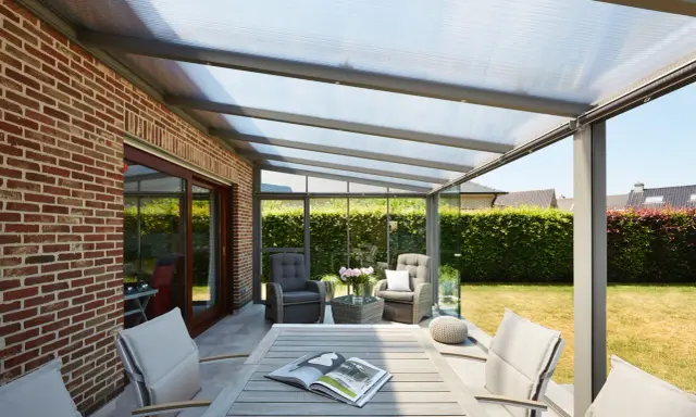 Une pergola moderne avec toit transparent, parfaite pour installer un salon extérieur confortable.
