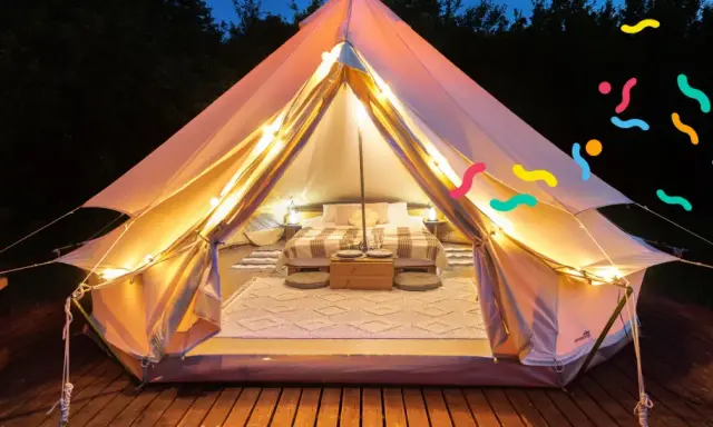 Tenda accogliente illuminata, perfetta per un'esperienza di glamping per famiglie. Letto comodo, tappeti e luci creano un'atmosfera magica.