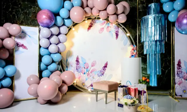 Jak udekorować salę na 18 urodziny? Balony, kwiaty i elegancka ścianka z motywem roślinnym stworzą magiczną atmosferę.