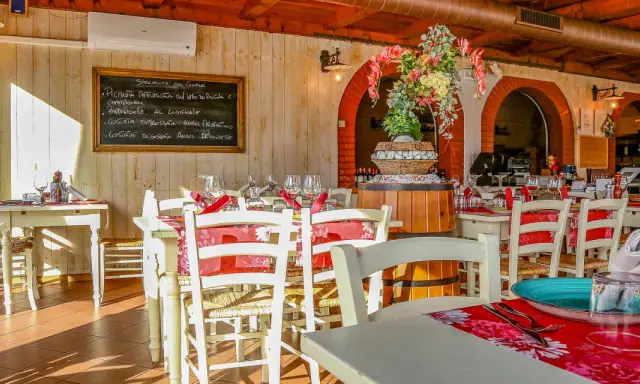 Interno di un ristorante di carne a Rimini centro, con tavoli apparecchiati e un menu scritto a mano.