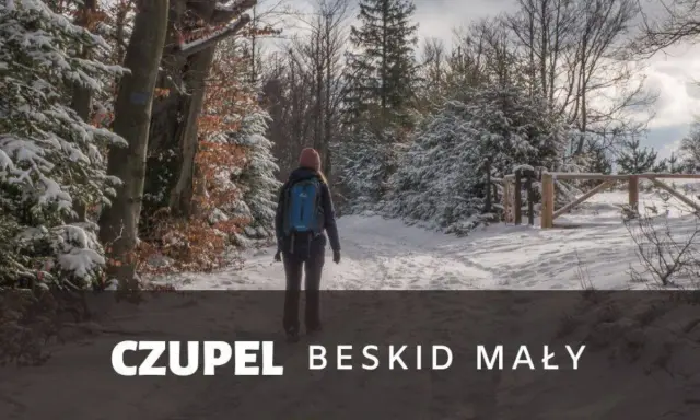 Kobieta w zimowej czapce i plecaku idzie zasypaną śniegiem trasą na Czupeł w Beskidzie Małym.