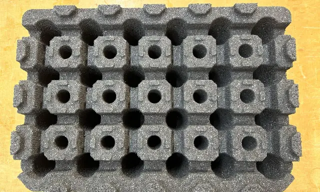 Graues epp kunststoff-Material mit vielen kleinen, quadratischen Hohlräumen, das wie eine Schachtel für empfindliche Gegenstände aussieht.