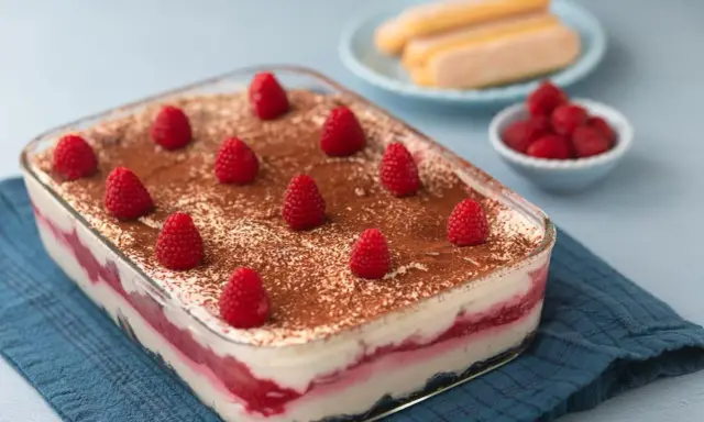 Himbeer Tiramisu mit Joghurt und Mascarpone, dekoriert mit frischen Himbeeren und Kakaopulver. Ein leichter Genuss!