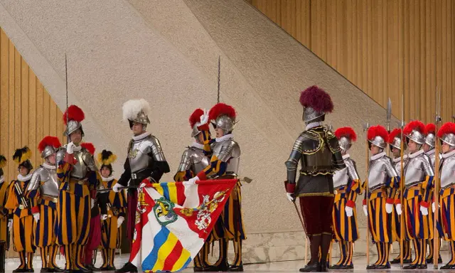 Guardie svizzere in alta uniforme, con alabarde e stendardo. Forse il loro celibato spiega perché le guardie svizzere non si possono sposare.