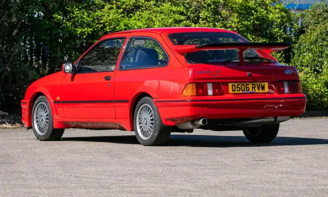 Roter Ford Sierra RS Cosworth mit großem Heckspoiler und markanten Felgen, bereit für die nächste Ausfahrt.