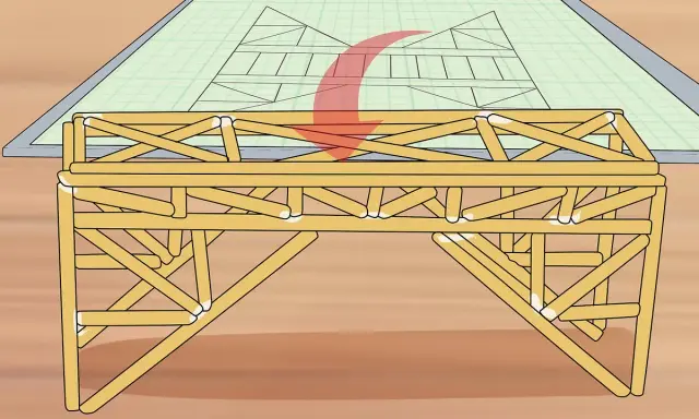 Un modelo de puentes de madera se construye sobre un plano de ingeniería.