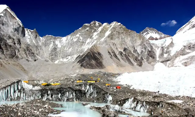 Niezwykły widok z bazy pod Mount Everest. Kolorowe namioty obozowe na tle lodowca i surowych, ośnieżonych szczytów. To początek ekscytującego **trekking pod Mount Everest**.