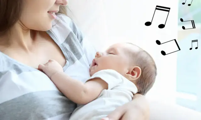 Mama śpiewa kołysankę dla dziecka, które zasypia w jej ramionach. Nutki unoszą się w powietrzu, tworząc magiczną atmosferę.