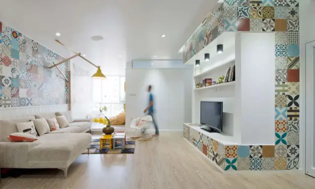 Un salon moderne avec une décoration murale audacieuse. Quelle déco avec des carreaux de ciment ! Le sol en bois clair complète l'ensemble.