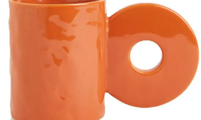 En orange mugg med ett cirkulärt handtag. Perfekt för ditt keramik hemma utan ugn-projekt.