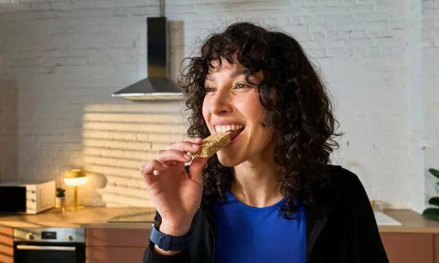 Frau isst einen Riegel, die perfekte Energie für das, was essen vor dem Training.