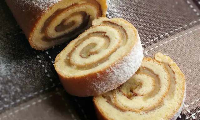 Pyszna, odwrócona rolada z jabłkami, posypana cukrem pudrem, kusi apetycznym wyglądem. Idealna na deser.