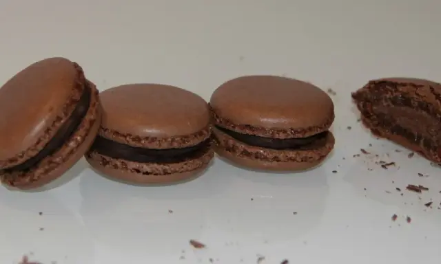 Trois macarons au chocolat et un croqué, parfaits pour une recette macaron chocolat.