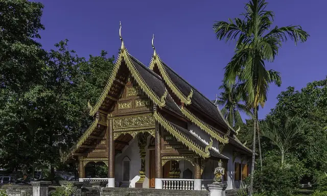 Złocone zdobienia świątyni w Chiang Mai, otoczonej bujną zielenią, to jedna z pięknych atrakcji miasta.