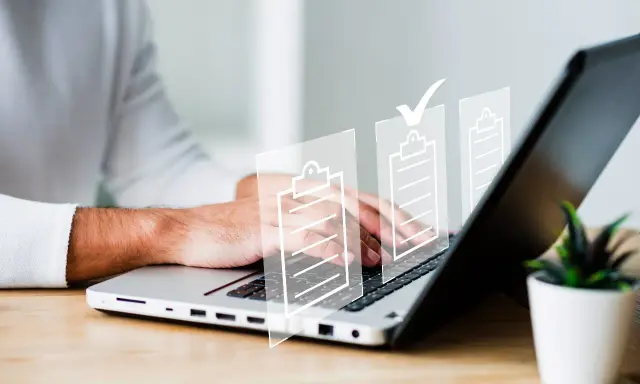 Man typing on laptop with digital checklists. It's important that es obligatorio registrar un contrato de alquiler.