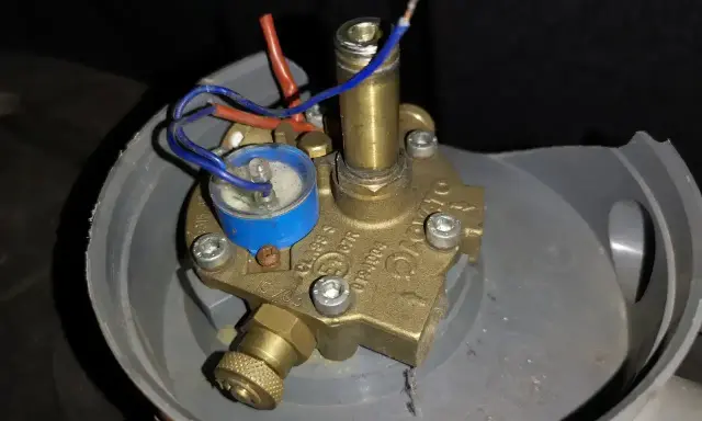 Uszkodzony elektrozawór LPG. Widoczne luźne przewody i korozja, potencjalne objawy awarii.