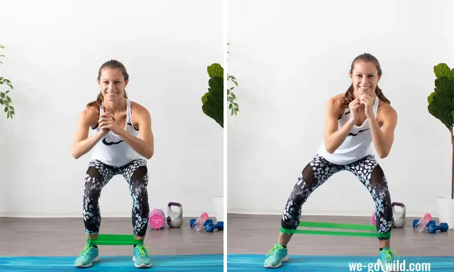 Frau trainiert den gluteus minimus mit einem Widerstandsband. Sie macht seitliche Ausfallschritte, um ihre Gesäßmuskeln zu stärken.