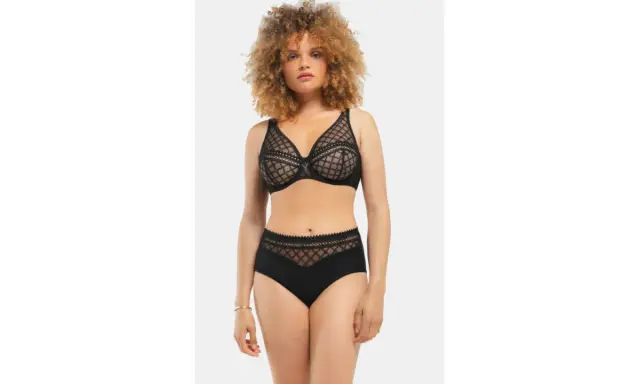 Modella con un seno largo indossa un completo intimo nero in pizzo trasparente.