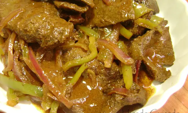 Sabroso hígado encebollado con pimientos verdes y cebolla morada en una salsa rica. Un plato casero reconfortante.