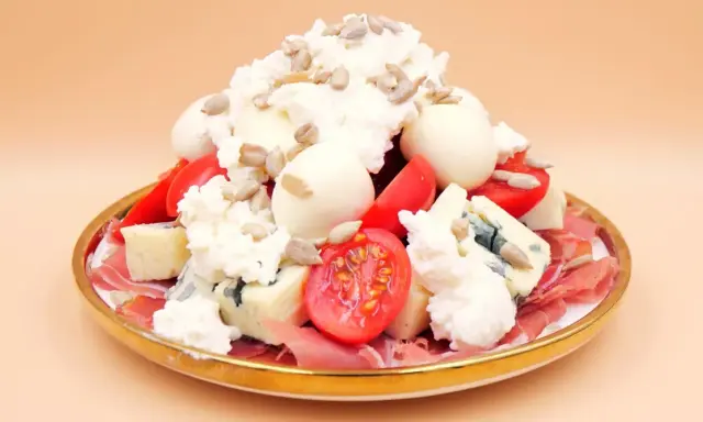 Wykwintna sałatka z szynką parmeńską, serami pleśniowymi, pomidorkami i słonecznikiem.