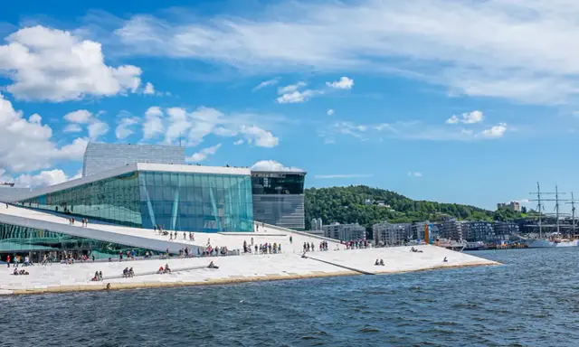 Ein sonniger Tag für Oslo Sightseeing am Opernhaus mit seiner einzigartigen Architektur und dem Wasser.