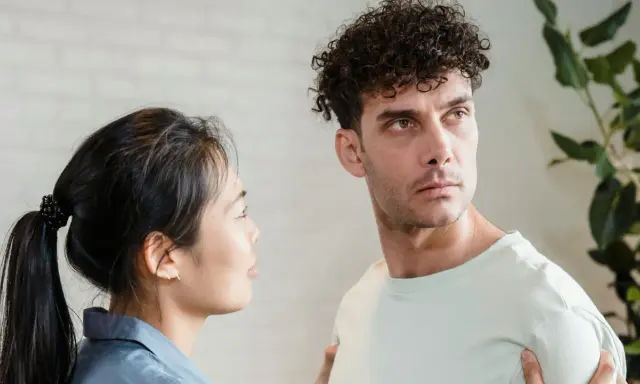 Un homme au regard intense, peut-être un pervers narci, semble ignorer une femme qui le regarde avec inquiétude.