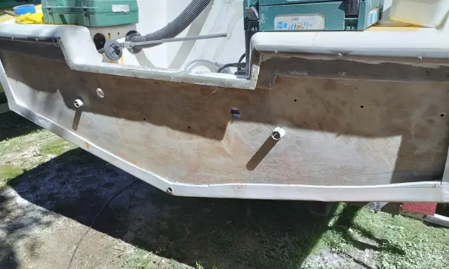 Préparation pour refaire le tableau arrière d'un bateau. Des outils et des matériaux sont visibles.