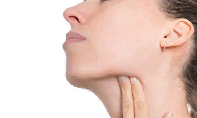 Donna si tocca il collo, preoccupata per possibili linfonodi tumore.
