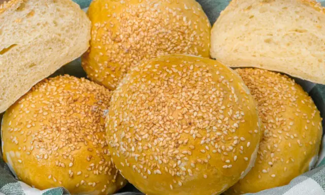 Koszyk pełen pysznych, złotych bułek bez drożdży, posypanych sezamem. Idealne na burgery lub jako dodatek do posiłku.