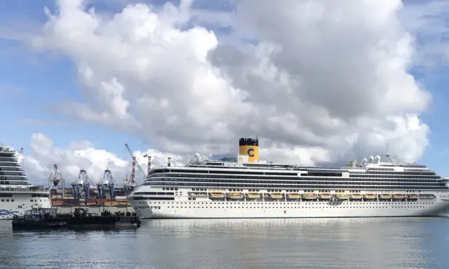 Grandi navi da crociera attraccate al terminal crociere La Spezia, con gru portuali sullo sfondo e un cielo nuvoloso.