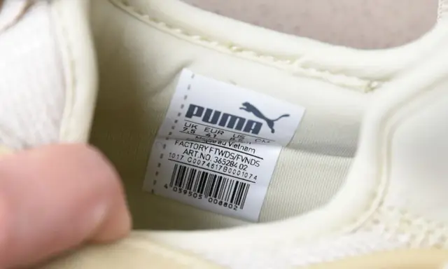 Oryginalna metka Puma na jasnej podeszwie buta, z informacjami o rozmiarze i pochodzeniu.